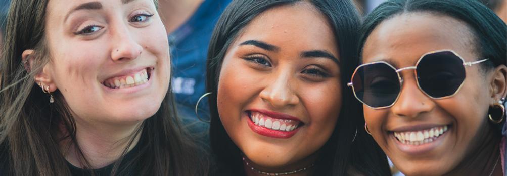 three female students smiling.