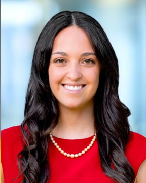 Woman smiling, looking at camera.