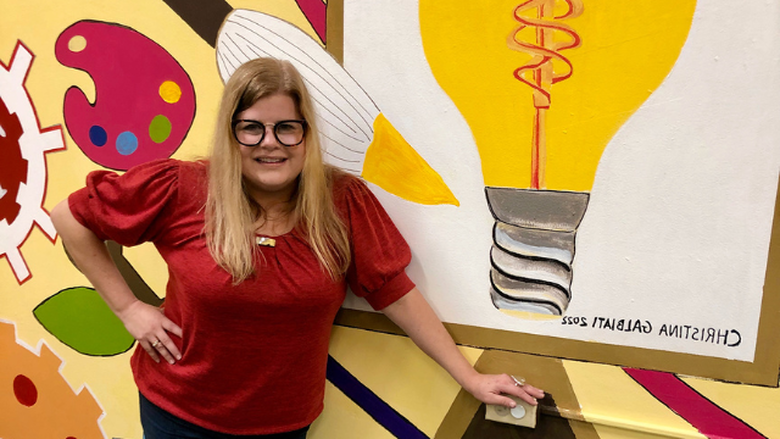 Christina Galbiati standing in front of STEAM-themed mural